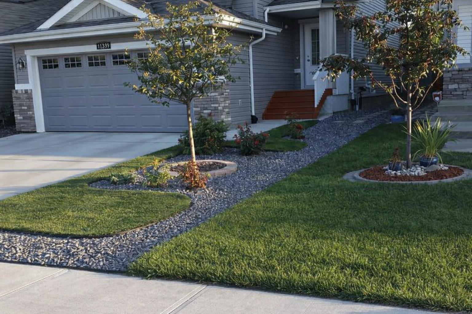 Well-maintained Edmonton front yard with tree ring garden beds and healthy green lawn